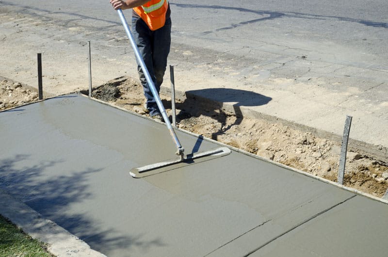 Employee finishing concrete sidewalk | Cimentiers Experts